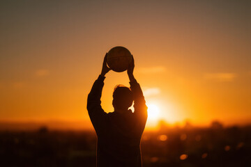 Poster - Silhouette of a person holding a globe up towards a vibrant sunset, a concept of global travel or world exploration. : Generative AI