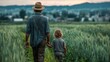 © Chandlerlikes - A farmer and his child walking through a green field, emphasizing the role of sustainability in agriculture.