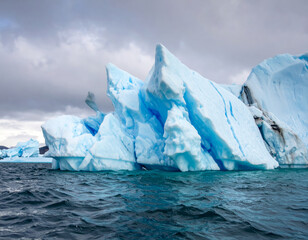 Wall Mural - Majestic icebergs rise dramatically from ocean, showcasing stunning blue hues and intricate formations. scene captures beauty of nature frozen art in serene environment