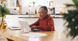 © peopleimages.com - Senior man, laptop and taxes in kitchen with typing, documents and financial review for pension. Elderly person, computer and paperwork with budget, will and planning for retirement income in home
