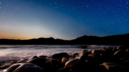 Wall Mural - sunrise over the sea with gentle waves and fading stars in a peaceful, dreamy atmosphere