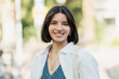 © Andrei - Bright Multiracial Asian Latina Middle Eastern young woman with trendy short hair smiling at the camera in a European street
