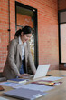 © mojo_cp - Woman using laptop working at contemporary office workplace