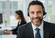 © Vooglo.com - Smiling man wearing a headset in a call center environment with a colleague in the background
