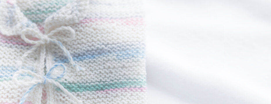 Gestricktes weisses Babyjäckchen auf weissem Hintergrund