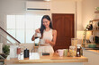 © Prathankarnpap - Smiling woman pouring freshly brewed coffee into a mug in a home kitchen