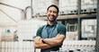 © EinFrame25/peopleimages.com - Distillery, happy and portrait of man with crossed arms for alcohol production, manufacturing and distribution. Warehouse, brewery business and confident person for fermentation, aging and drinks