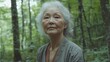 © Iuliia Metkalova - Serene Mature Elderly Woman in Sunlit Forest - Nature Connection and Tranquility.  Forest bathing concept