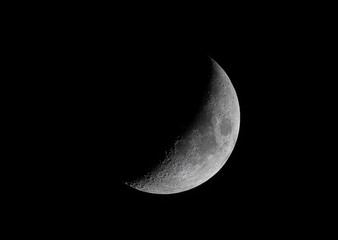 Wall Mural - waxing crescent moon glowing taken may 2, 2025 above ottawa, canada against a black background.