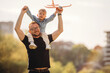 © standret - Sitting on shoulders, with toy plane. Father and son are having fun outdoors
