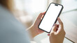 © matinee - Hands using mobile phone with empty display ready for design, app interface showcase or digital product preview.