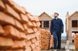 © Serhii - Installing brick wall. Construction worker in uniform and safety equipment have job on building