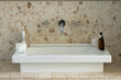 © Wavebreak Media - White sink basin is sitting on stone countertop, displaying chrome faucet and cosmetic bottles