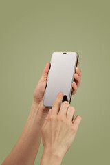 female hand holding and clicking , typing on smartphone display isolated on green background, mockup , woman using smart phone