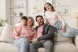 © New Africa - Portrait of happy family on sofa at home