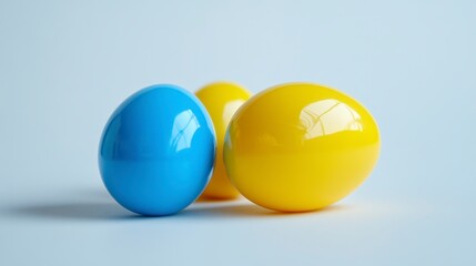Poster - Three shiny Easter eggs, one blue and two yellow, on a light blue background.