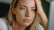 © surga - Close-up shot of a weary woman, hand on her head, staring intently