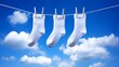 © Tida - Three White Socks Drying in the Sun - Pure, fresh, clean, simple, and airy. Three white socks hanging on a clothesline against a bright blue sky symbolize cleanliness, freshness