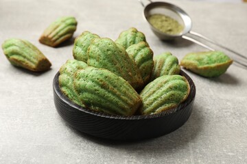 Wall Mural - Tasty madeleine cakes and matcha powder on light table, closeup