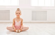 © Prostock-studio - Portrait of little ballerina on floor, copy space. Smiling baby girl dreaming to become professional ballet dancer, classical dance school
