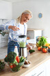 © Pixel-Shot - Mature woman making healthy smoothie with blender in kitchen
