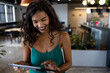 © WavebreakMediaMicro - Young African American woman using tablet in modern office lounge, wearing smartwatch and smiling