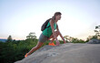 © bilanol - Sportive woman climbing alone on hillside rocky trail. Female hiker overcoming difficult cliff on wilderness path. Active lifestyle concept