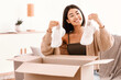 © Prostock-studio - Portrait of smiling asian woman received package, unpacking cardboard box with shoes, holding and looking at white sneakers, sitting on the sofa at home. Female buyer satisfied with online shopping