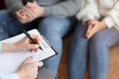 © Prostock-studio - Family Psychologist. Professional Marriage Consultant Taking Notes Talking With Couple Sitting In Office. Selective Focus, Cropped