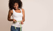 © Prostock-studio - Fitness concept. African-american woman measuring waist and looking on tape over light background