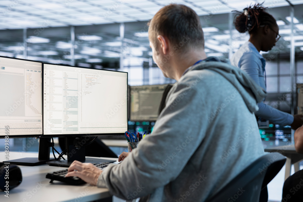 IT engineer looking at PC screen, working in network security data ...