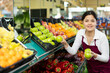 © JackF - Young woman in apron working in salesroom of greengrocer, setting out fruits on shelves