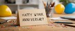 © Ross - Happy work anniversary card on desk with balloons, confetti, and office supplies around it