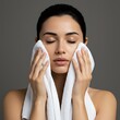 © Laki - Woman gently drying her face with a soft white towel after cleansing, eyes closed