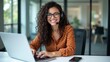 © Ada - Portrait of Latin American business woman, office worker looking at camera and smiling, using headset and laptop for remote online communication, customer support tech call center worker.