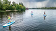 © Iuliia Sokolovska - Active family on SUP, standing up paddleboards, river water adventure, summer family sport, aerial drone view from above