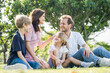 © Nopphon - Happy family parent children having picnic outdoor activity. Enjoy happiness moment summer playing together including father mother son and daughter relaxing in the morning sunrise.