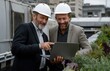 © yevgeniya131988 - Engineers using laptop while inspecting rooftop garden with hvac system