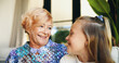 © peopleimages.com - Bonding, family or love with grandmother and grandchild on sofa in living room of retirement home for visit. Happy, relax or smile with girl and old woman in apartment for weekend conversation