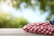© Nittaya - Checkered cloth with USA flag pattern on wooden table outdoors