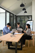 © saltdium - Three professionals, businesspeople in a modern office setting, reviewing documents, analyzing data, and discussing business strategy