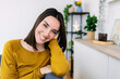 © Xavier Lorenzo - Portrait of happy young woman sitting on cozy sofa, enjoying a relaxing moment at home
