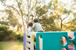 © Austockphoto - Brother and sister playing on climbing castle together in the garden