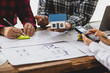 © Wasan - Architects and engineers are having a meeting in their office. They are working on a construction project and using a calculator to calculations. Building construction design and plan project budget.