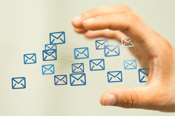Hand interacting with a network of email icons, symbolizing global communication and connectivity.
