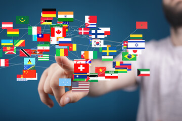 Leinwandbilder - Hand interacting with a digital display of world flags, symbolizing global connectivity and international relations.