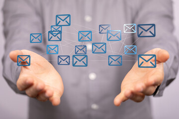 Fototapete - Person's hands presenting a network of email icons, symbolizing global communication and interconnectedness.