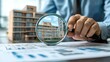 © Weather - A person meticulously examines an apartment building model and blueprints, signifying property assessment and detailed planning
