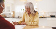 © peopleimages.com - Old man, financial advisor and writing on paperwork in home for insurance application, pension fund and contract. Happy, woman and elderly patient with documents for mortgage loan or asset management