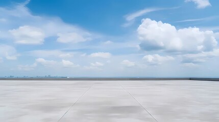 Fototapete - 広いコンクリートの表面と都市のスカイラインの背景に浮かぶ白い雲と晴れた青空の静かな風景